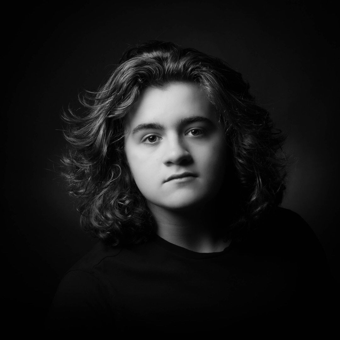 Studijski portret žene srednjih tridesetih s smeđom kosom koja se osmjehuje